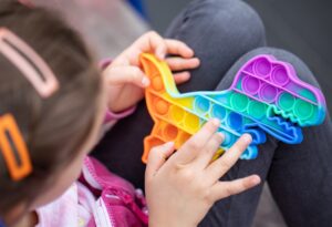 popular_colorful_anti_stress_touch_toy_dragon_shaped_fidgets_push_pop_it_in_the_hands_of_a_child-9647690