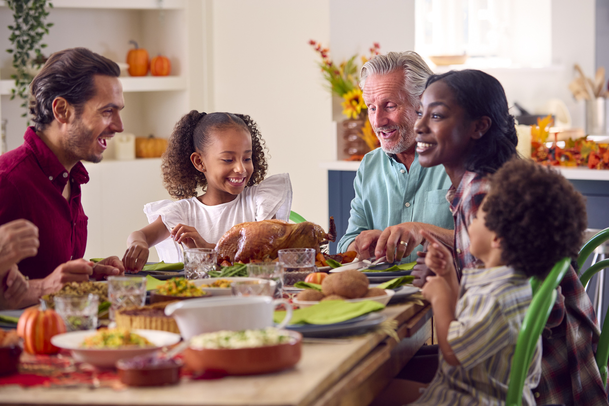 Multi-Generation Family Celebrating Thanksgiving At Home Eating Meal Together