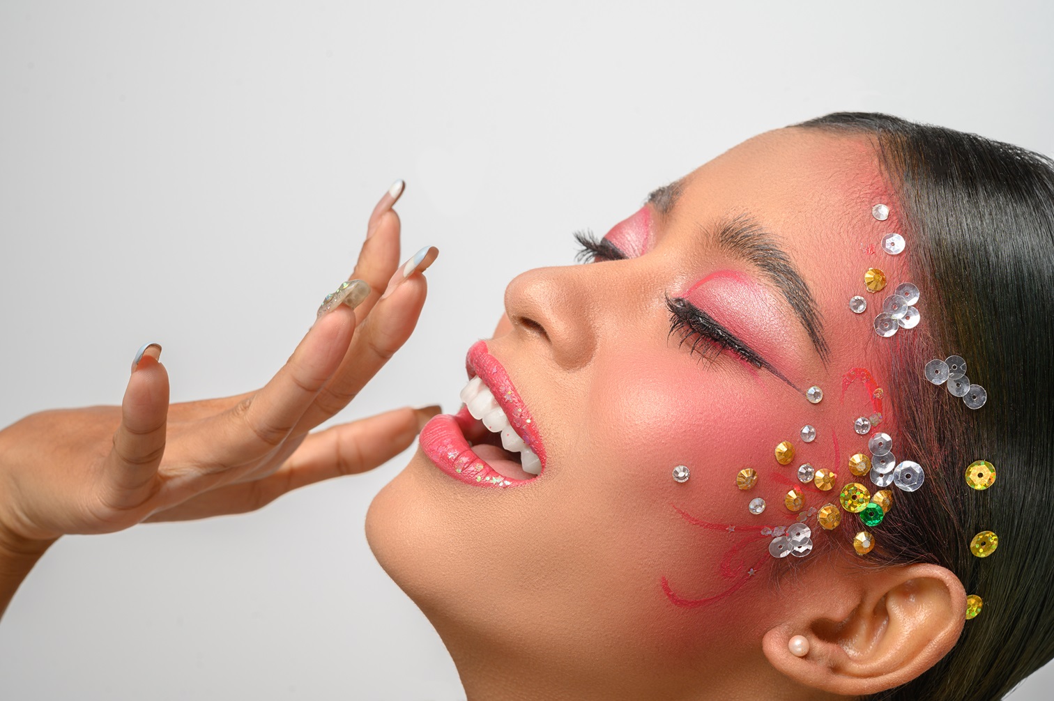 Woman wearing pink makeup and embellishments on her face